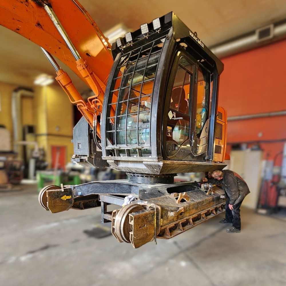 Hitachi ZX245US high and wide undercarriage in welding shop being inspected