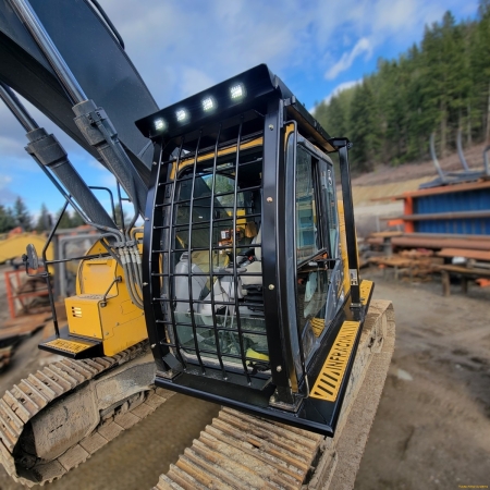 John Deere excavator with FOPS and catwalks in a shop yar